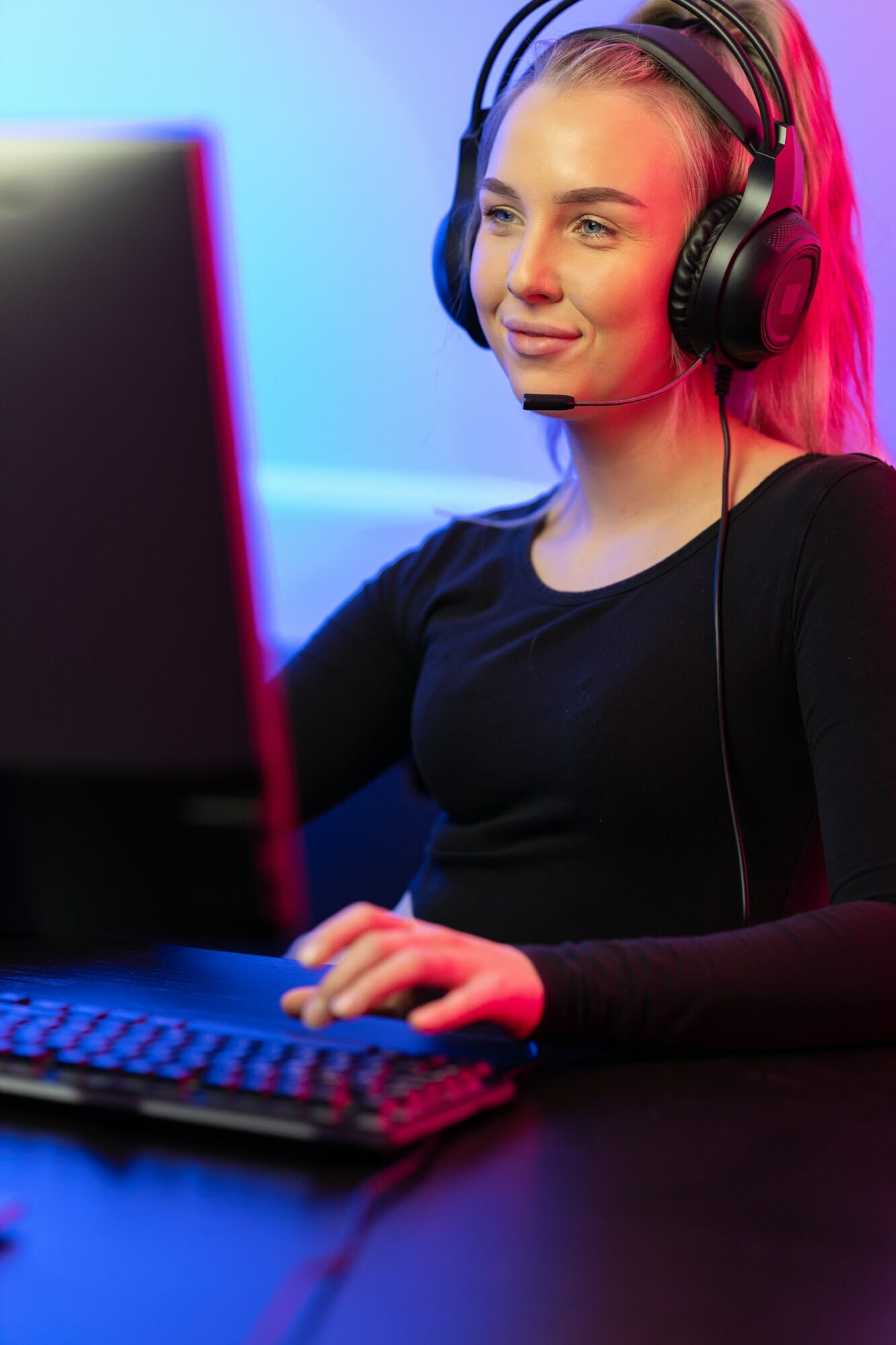 Smiling Professional E-sport Gamer Girl with Headset Playing Online Video Game