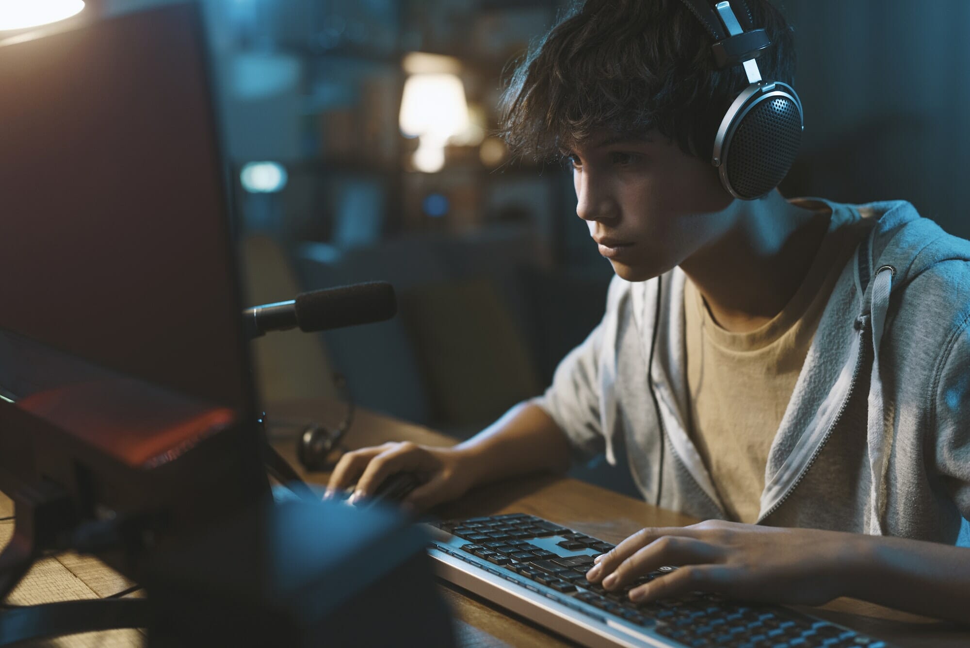 Teenager wearing headphones and playing online puzzle video games