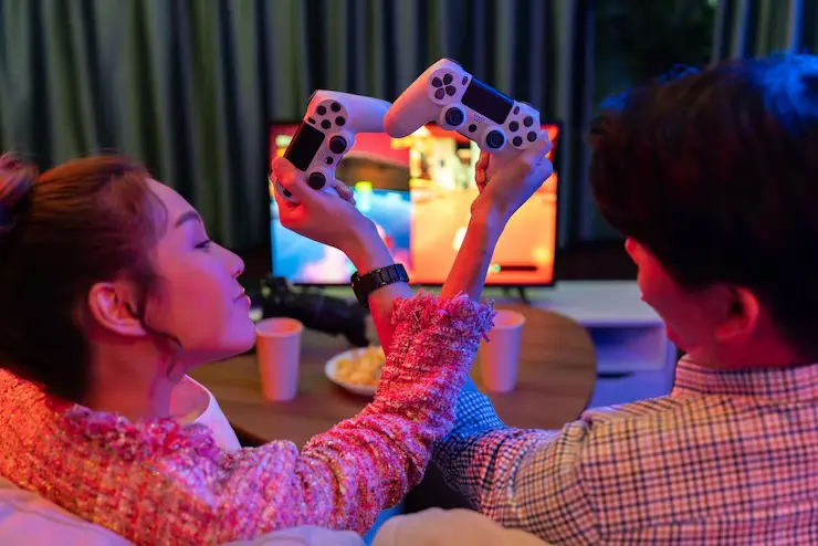 Multiplayer Game Development Multiplayer Game Development Agency couple gaming together with controllers raised