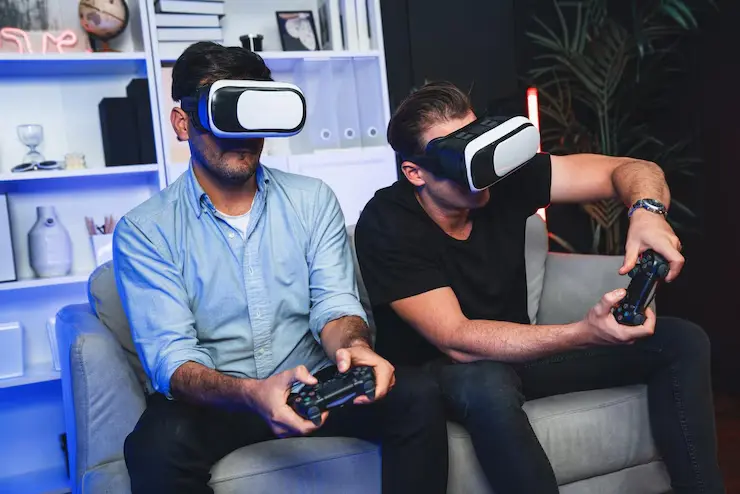 Two developers testing metaverse game development with VR headsets and controllers in modern office