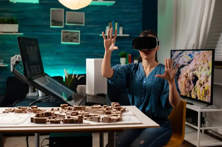 Woman developer using VR headset for metaverse game development with architectural models on desk