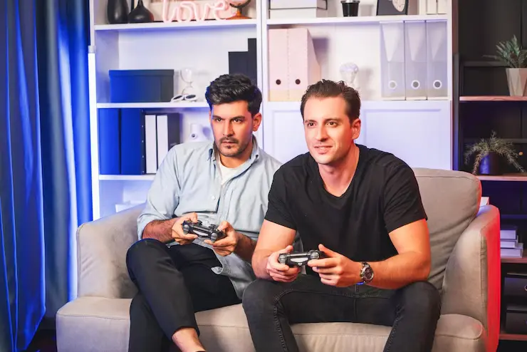 Unreal Engine Game Development Agency duo engaged in console gameplay on a couch
