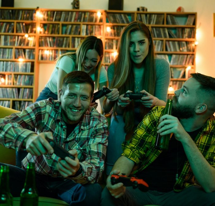 Friends gathered at home playing video games on a console.