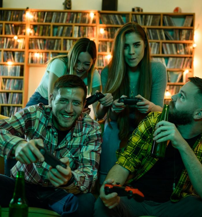 Friends gathered at home playing video games on a console.