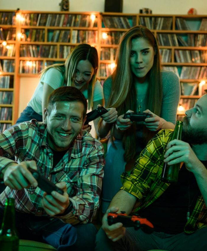Friends gathered at home playing video games on a console.