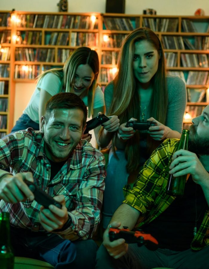 Friends gathered at home playing video games on a console.