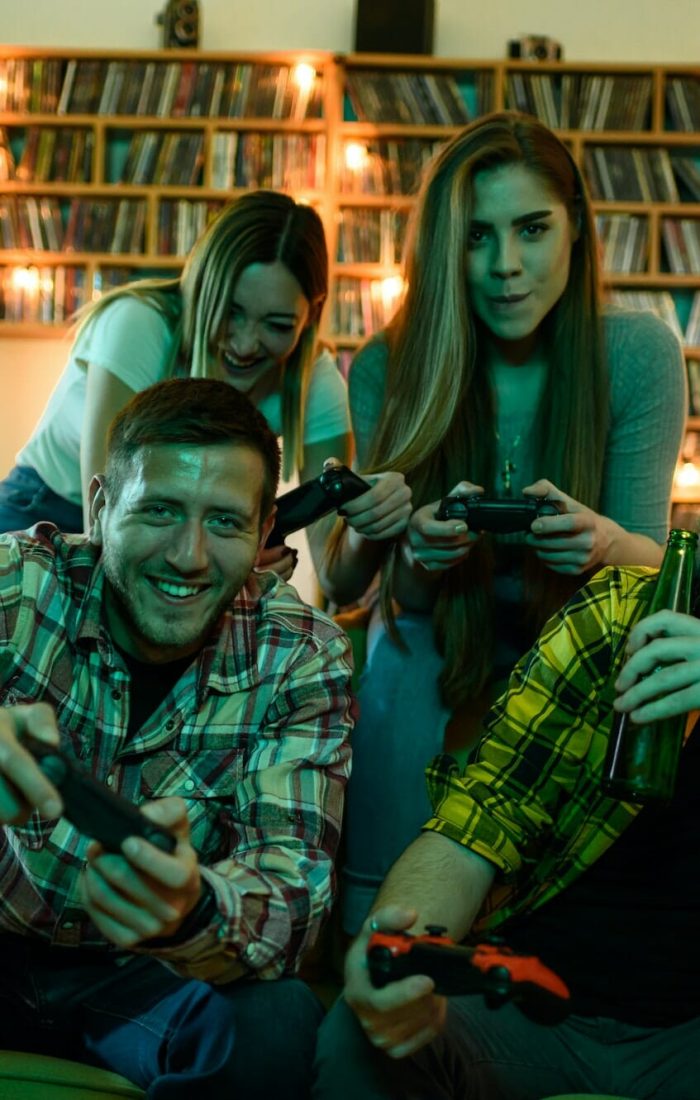 Group of Friends Playing Console Games at Home Friends gathered at home playing video games on a console.