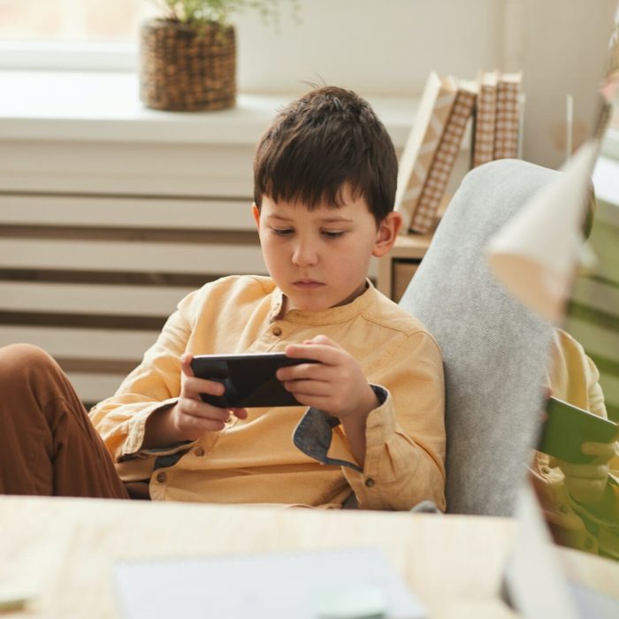 Excited Boy Playing VR Mobile Games with Focused Engagement