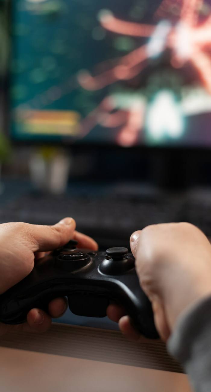 Close up of gamer holding controller to play video games