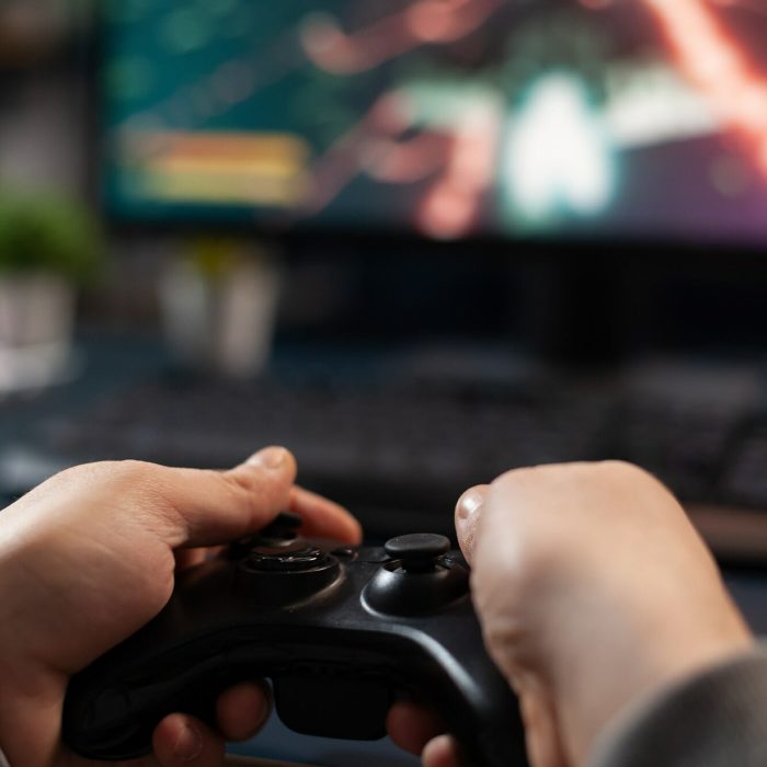 Close up of gamer holding controller to play video games