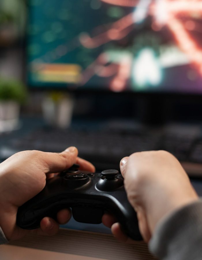 Close up of gamer holding controller to play video games