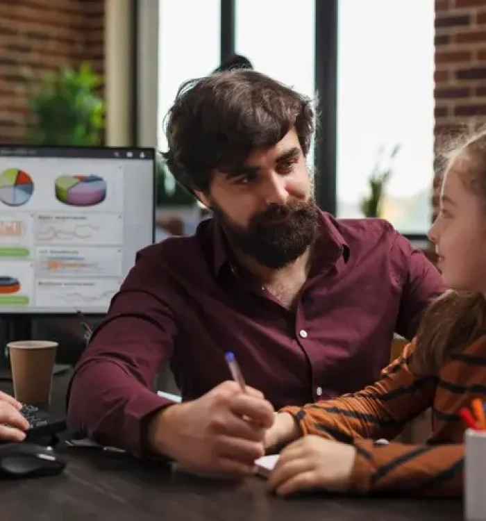 company-office-young-worker-talking-with-little-girl-while-sitting-desk-smiling-child-conversating-project-manager-business-man-while-modern-agency-sitting-table_482257-38632