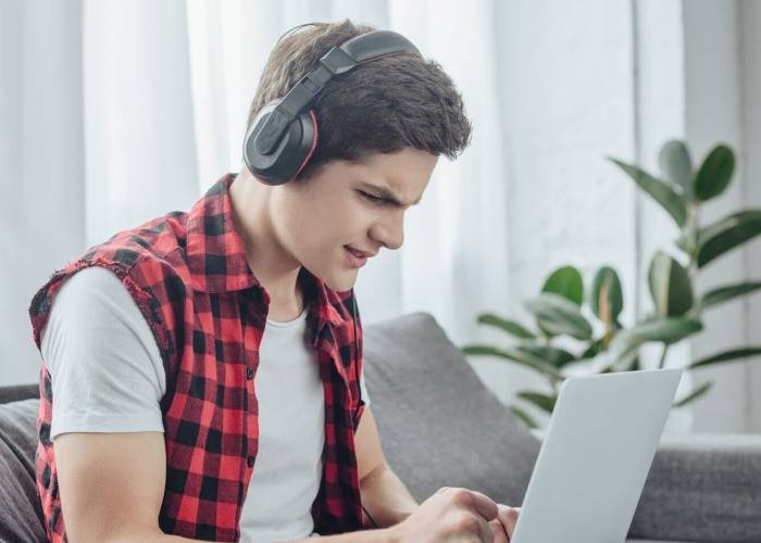 a boy playing game on laptop