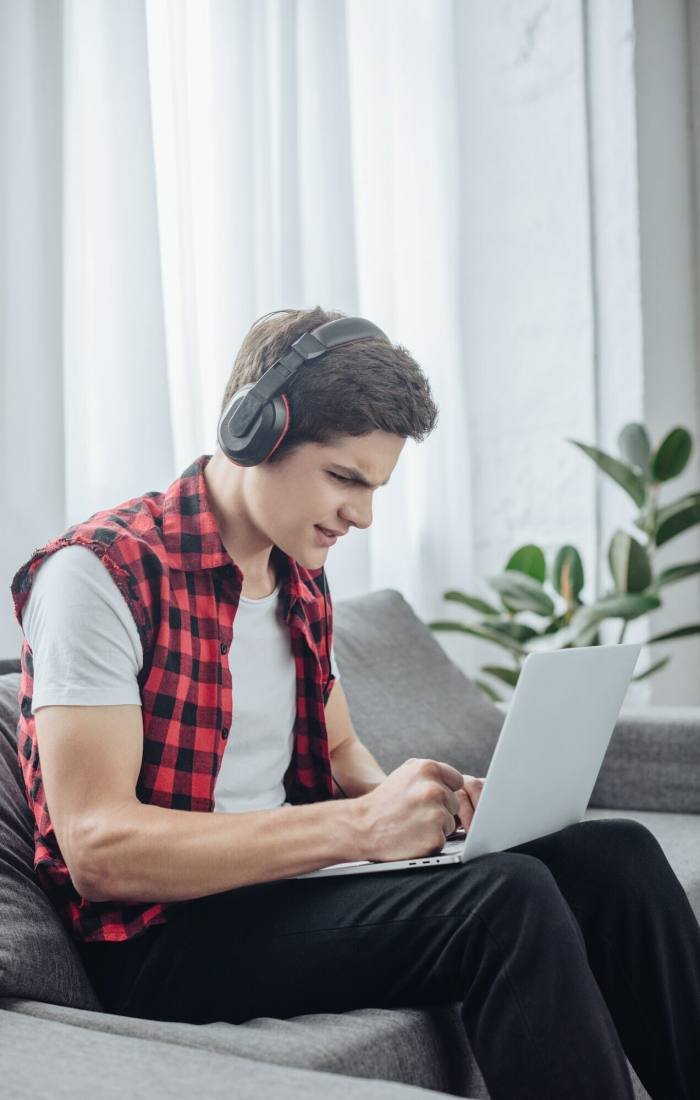 a boy playing game on laptop