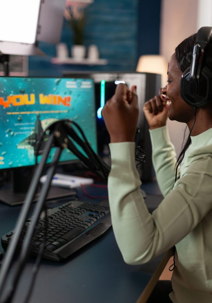 Excited winner pro gamer woman playing online videogames