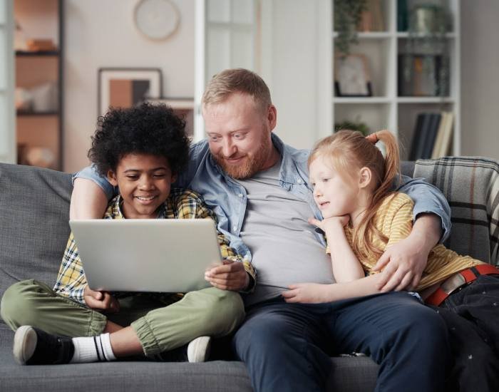 Father with children using laptop at home, Roblox Development Studio