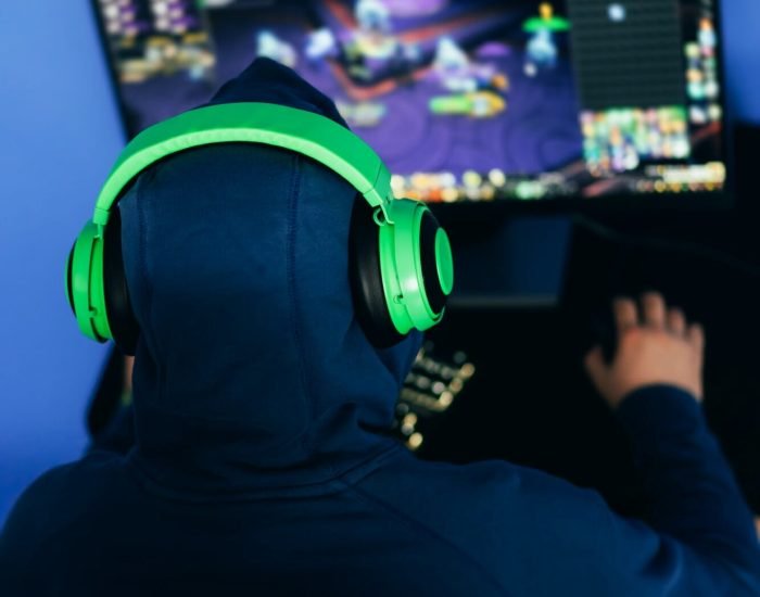 Gamer playing a PC game in a dimly lit room.