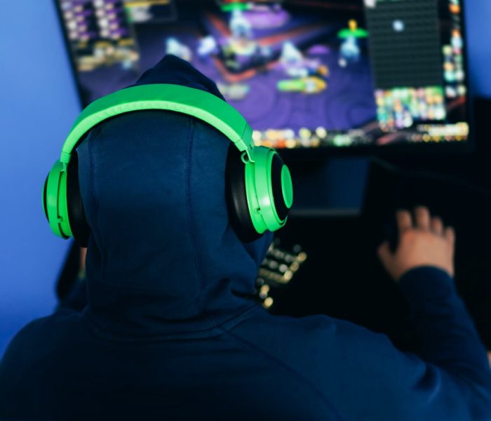 Gamer playing a PC game in a dimly lit room.
