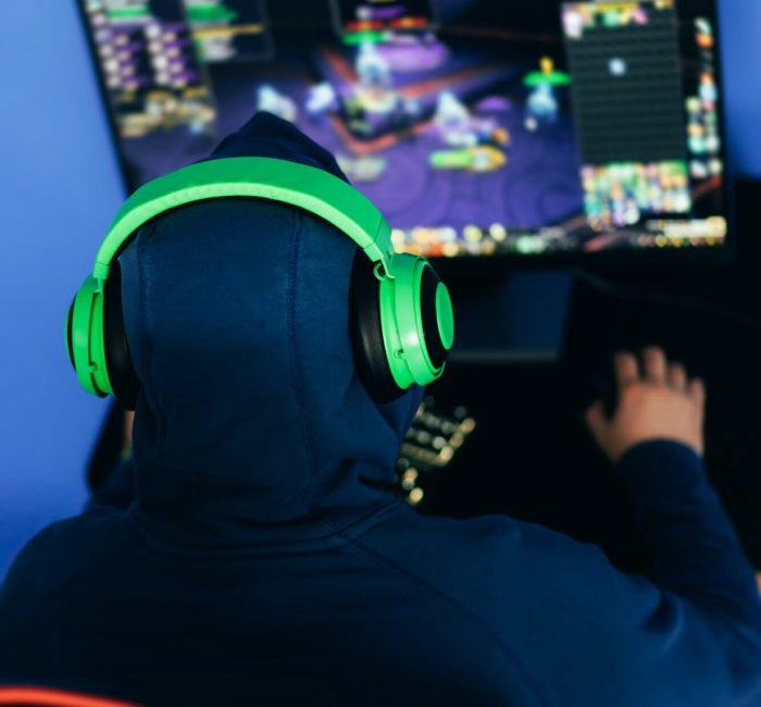 Gamer playing a PC game in a dimly lit room.