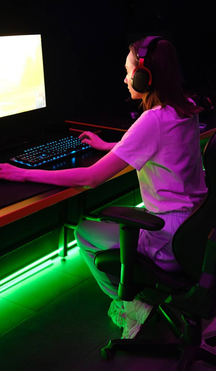 A girl playing a game developed by Pearl Lemon Game Development Agency on her computer.