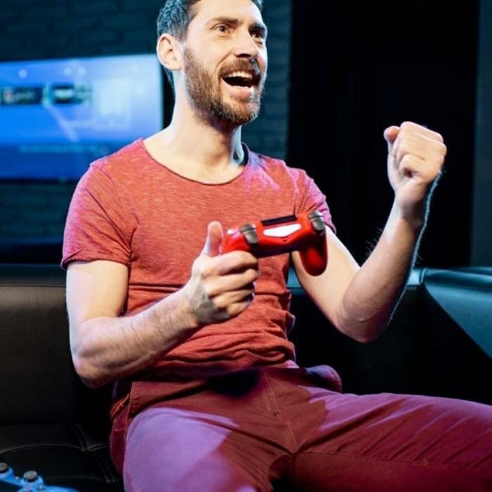 Smiling man playing video games in a club—hire professional Roblox game developers for engaging user experiences.