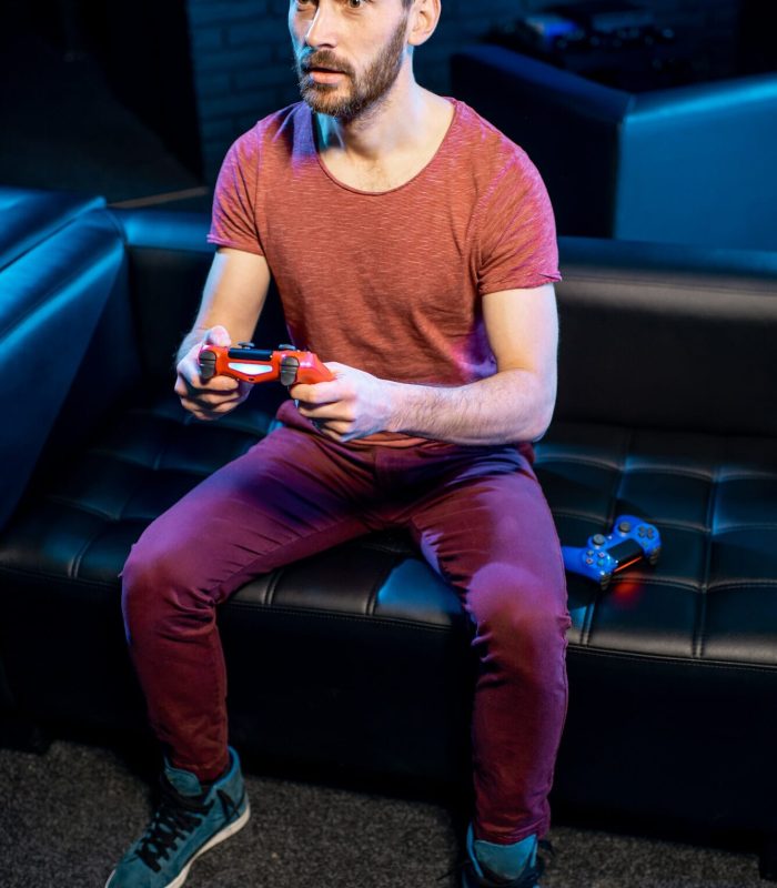 Gamer enjoying video games on a console in a lively club environment Man playing video games with gaming console in the club, Life Simulation Games Development Agency