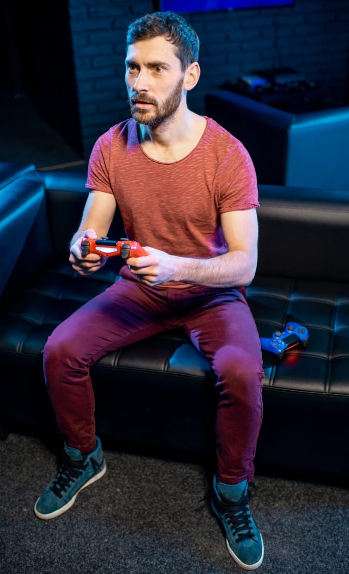 Gamer enjoying video games on a console in a lively club environment Man playing video games with gaming console in the club, Life Simulation Games Development Agency