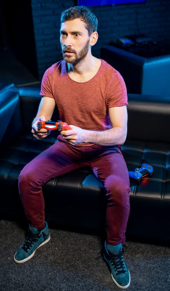 Gamer enjoying video games on a console in a lively club environment Man playing video games with gaming console in the club, Life Simulation Games Development Agency