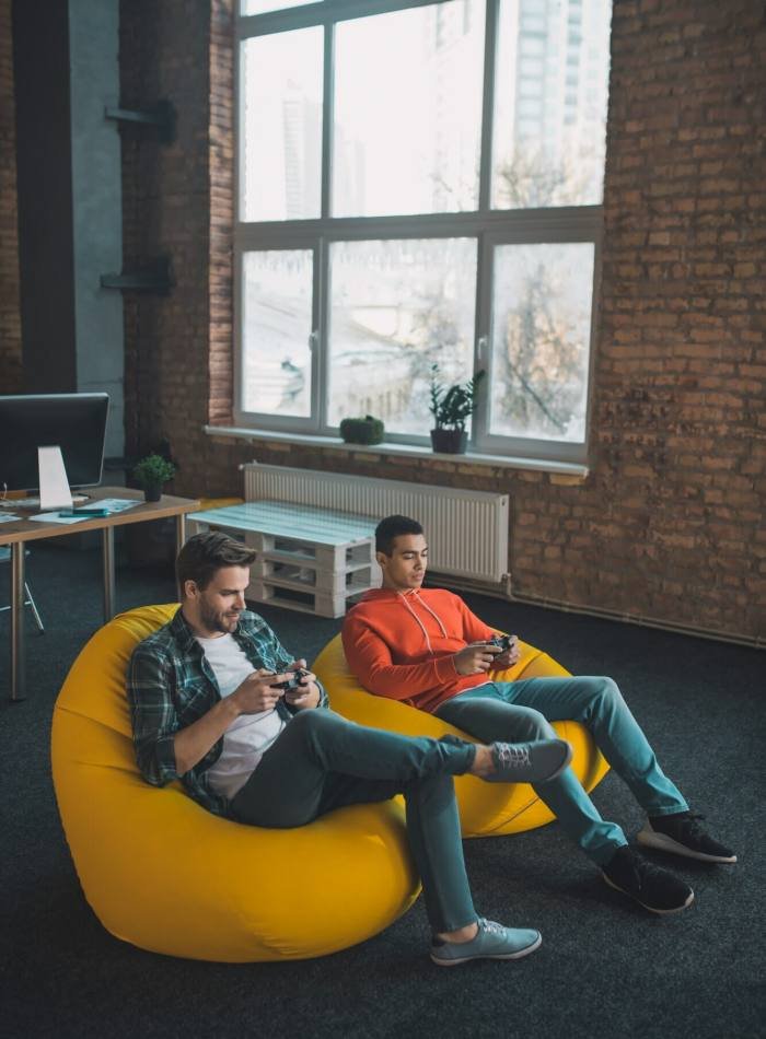 Pleasant happy men playing video games together