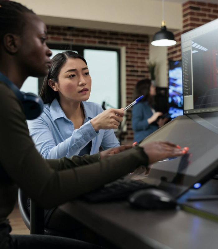 3D artist leader creating digital models on a multi-screen workstation.