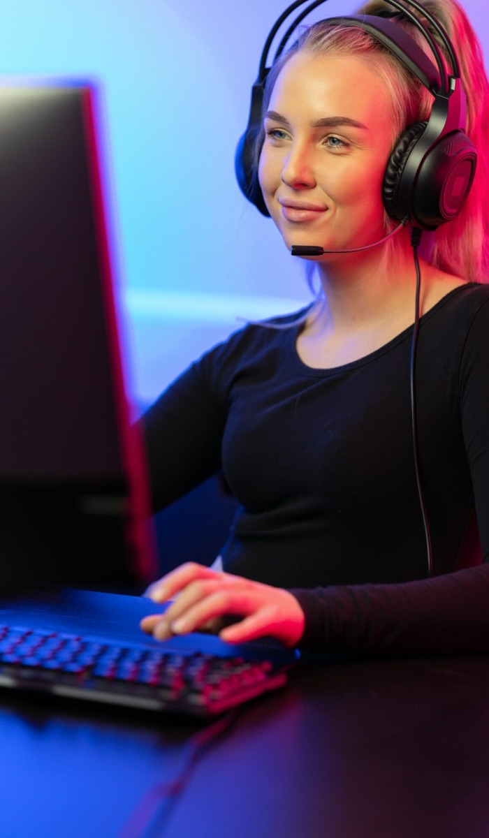 Smiling Professional E-sport Gamer Girl with Headset Playing Online Video Game