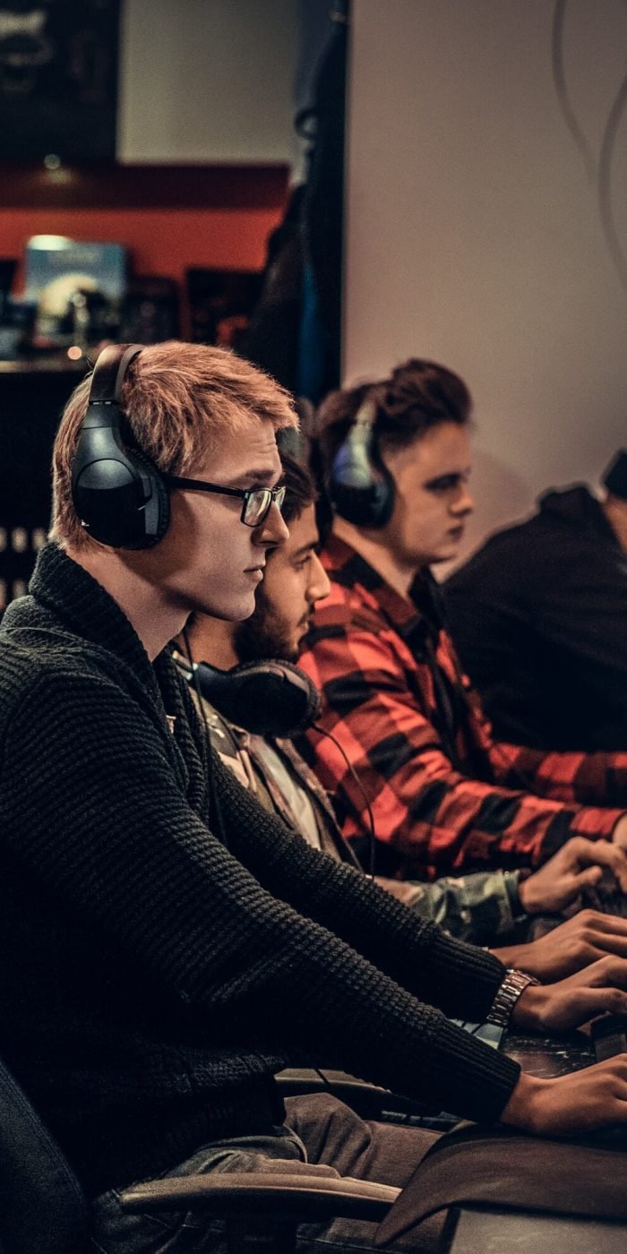 Team of teenage gamers plays in a multiplayer video game on pc in a gaming club.