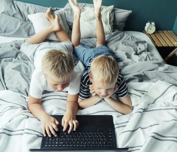 The boys playing the computer game laugh and have fun. Children spending time at home Mobile Game Marketing Agency