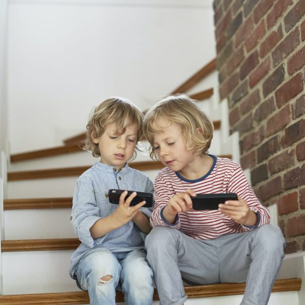 Young gamers using smartphones, ideal scene for social mobile game marketing.