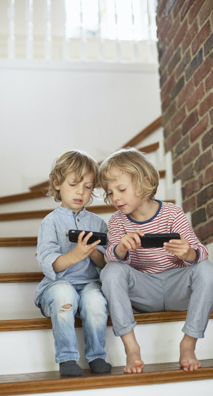 Young gamers using smartphones, ideal scene for social mobile game marketing.