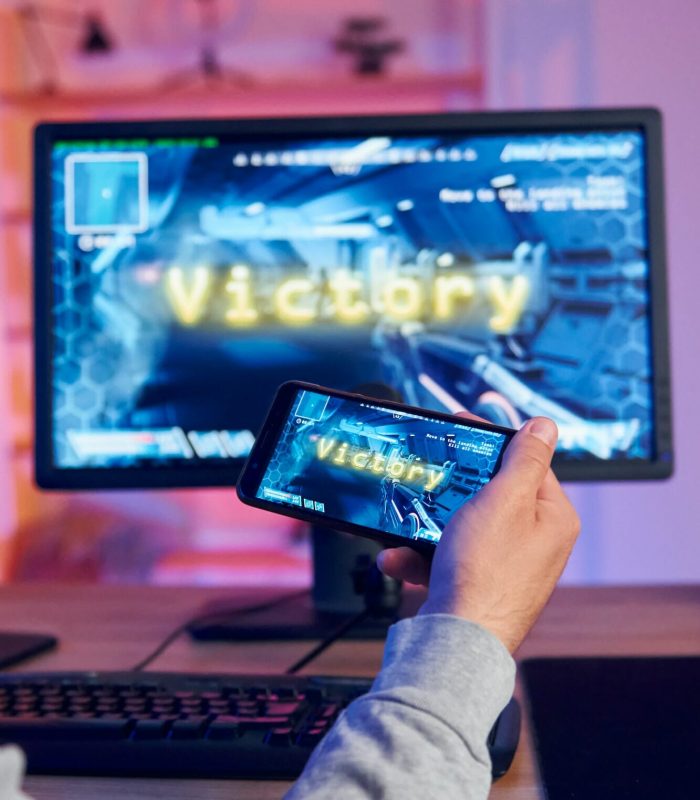 Victory, happy man celebrating. Online streamer playing FPS shooter game at home