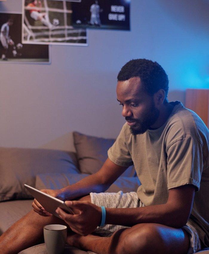 Young serious African sportsman in activewear watching online game